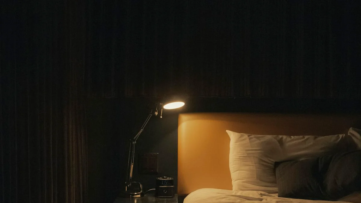 A small bedside lamp and an alarm clock glow beside a bed in a dark bedroom at night. — a The Obsidian Key guide to A Bedroom Holding a Phone.