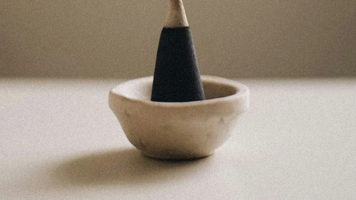 A dark incense cone smolders in a small cream bowl, a thin thread of smoke rising up a warm beige wall. — a The Obsidian Key guide to Cleansing a Space: Salt Sound and Smoke as Focus.