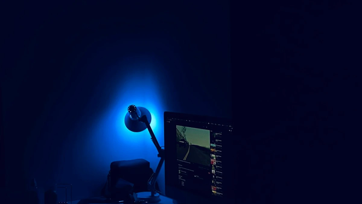 A glowing blue desk lamp and an open monitor light a dark room at midnight. — a The Obsidian Key guide to Emotional Spending Is Leakage in Pure Form.