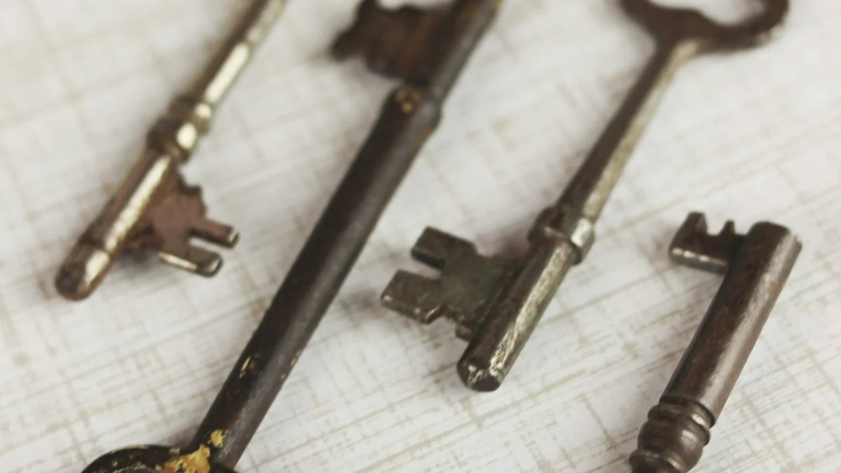 Antique brass skeleton keys, one large ornate key at the center, scattered across weathered wooden boards. — a The Obsidian Key guide to The Obsidian Key Ritual: What the Book Prescribes Daily.