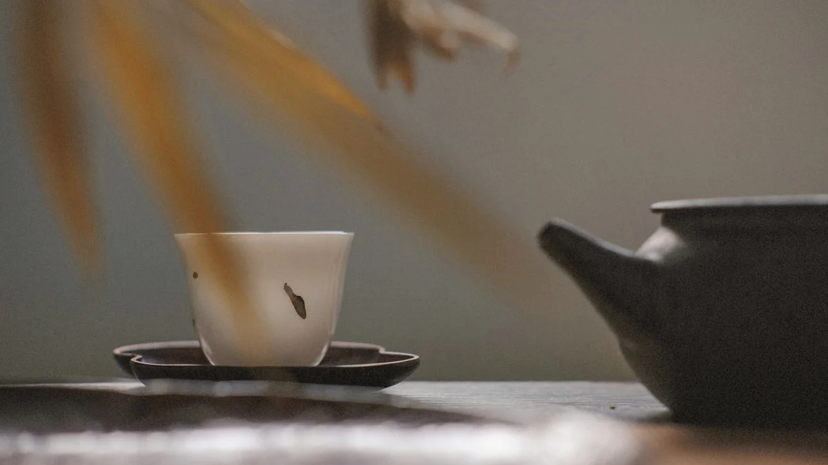 A white tea cup rests on a dark saucer beside a black clay teapot in soft morning light. — a The Obsidian Key guide to Does the Obsidian Key Help With Emotional Regulation.