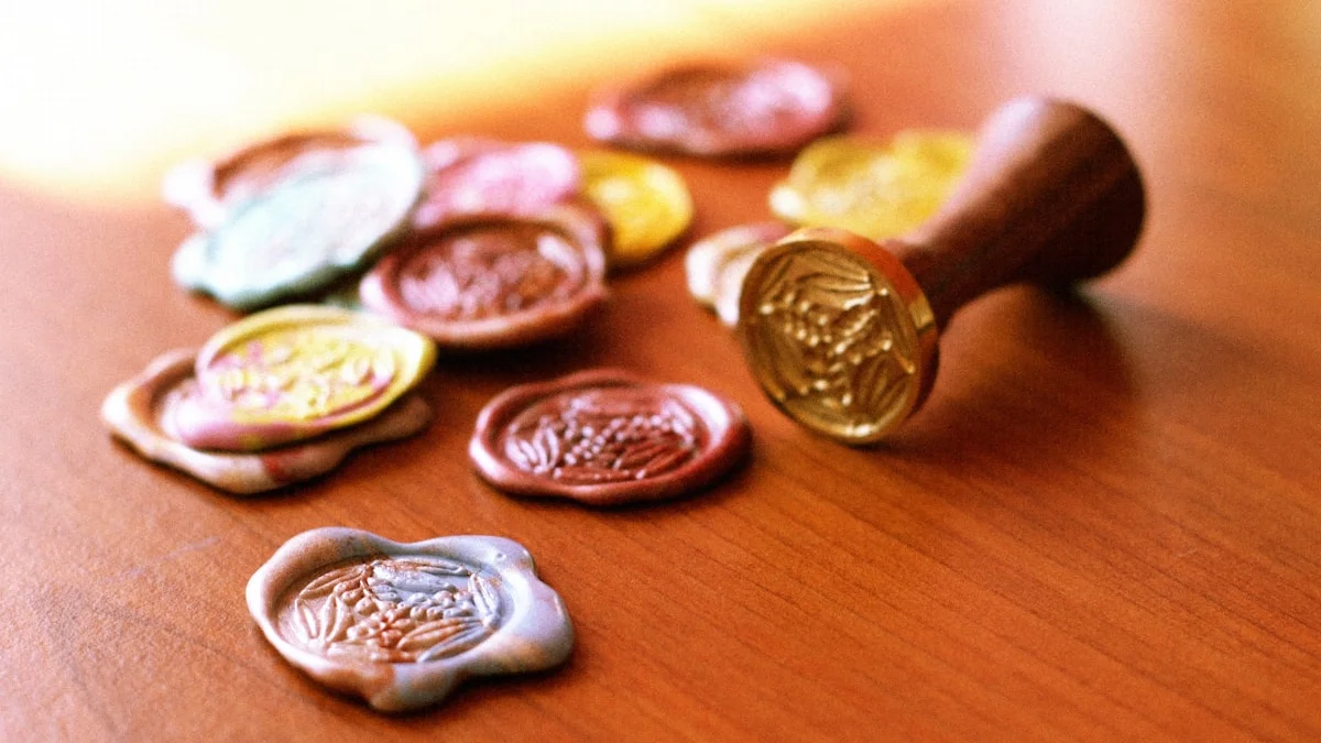 Colorful wax seals and a wooden-handled brass stamp rest on a warm wooden table. — a The Obsidian Key guide to Pay Yourself First as a Signal Not a Budget Line.