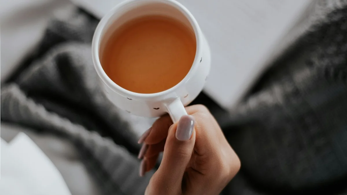 Hand holding a warm cup of tea over an open book in soft morning light. — a The Obsidian Key guide to Regulate Your Nervous System Before You Ask.