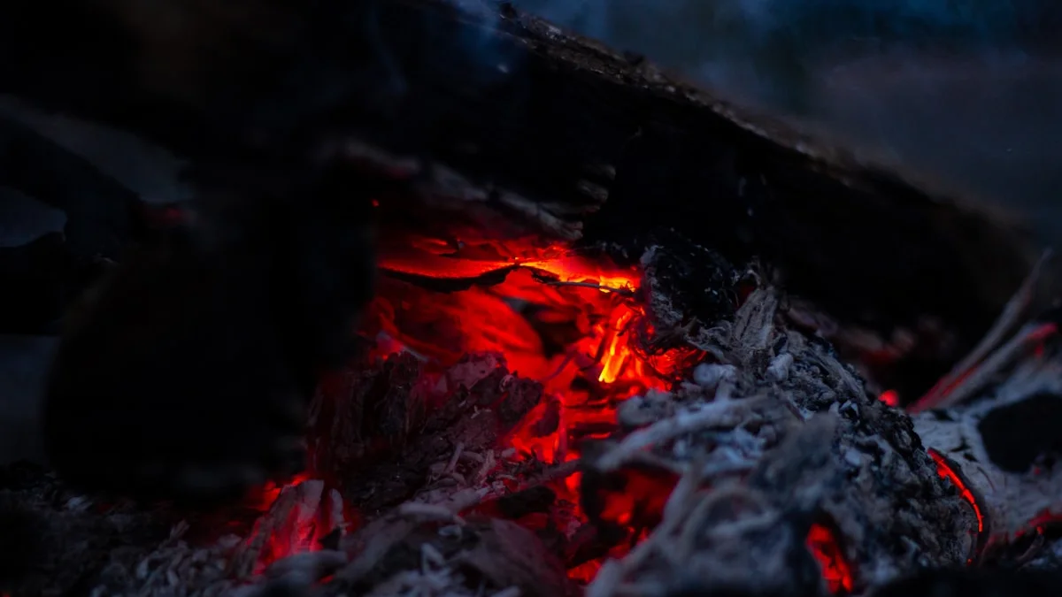 Red embers glow low beneath charred wood in the dark. — a The Obsidian Key guide to Relief vs Excitement: The Proof You Are Inside.