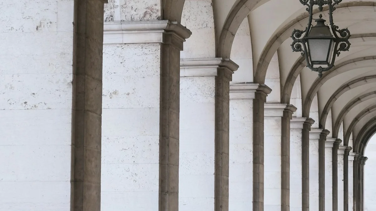 A pale stone colonnade of repeating arches with one hanging lantern in soft morning light. — a The Obsidian Key guide to The First Law: Stillness Precedes Power.